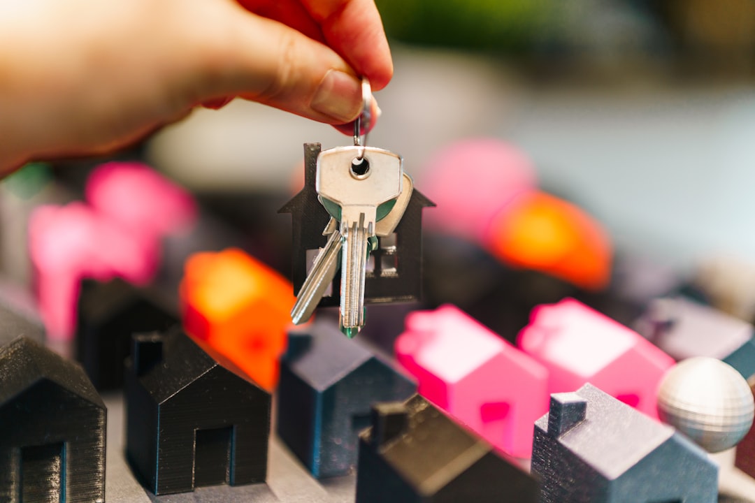 college dorm support animal — Hand holding house keys over miniature houses