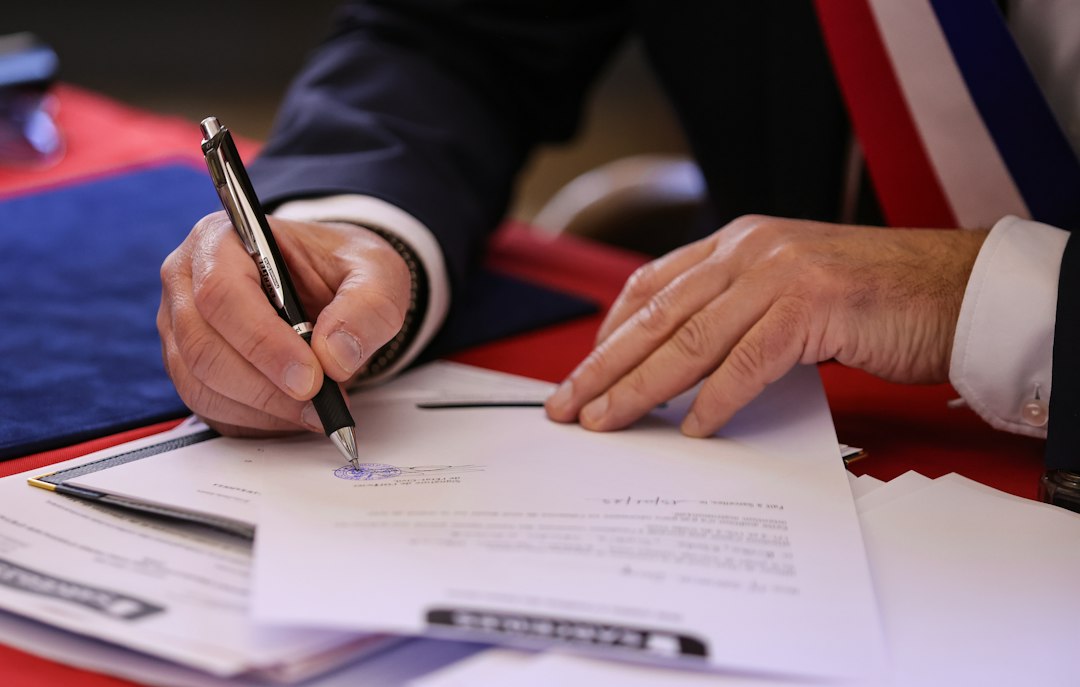 Colorado support animal laws — A person signs a document with a pen